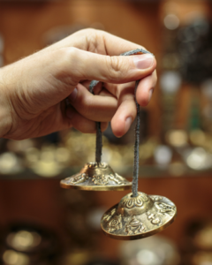 photo of a hand holding meditative chimes